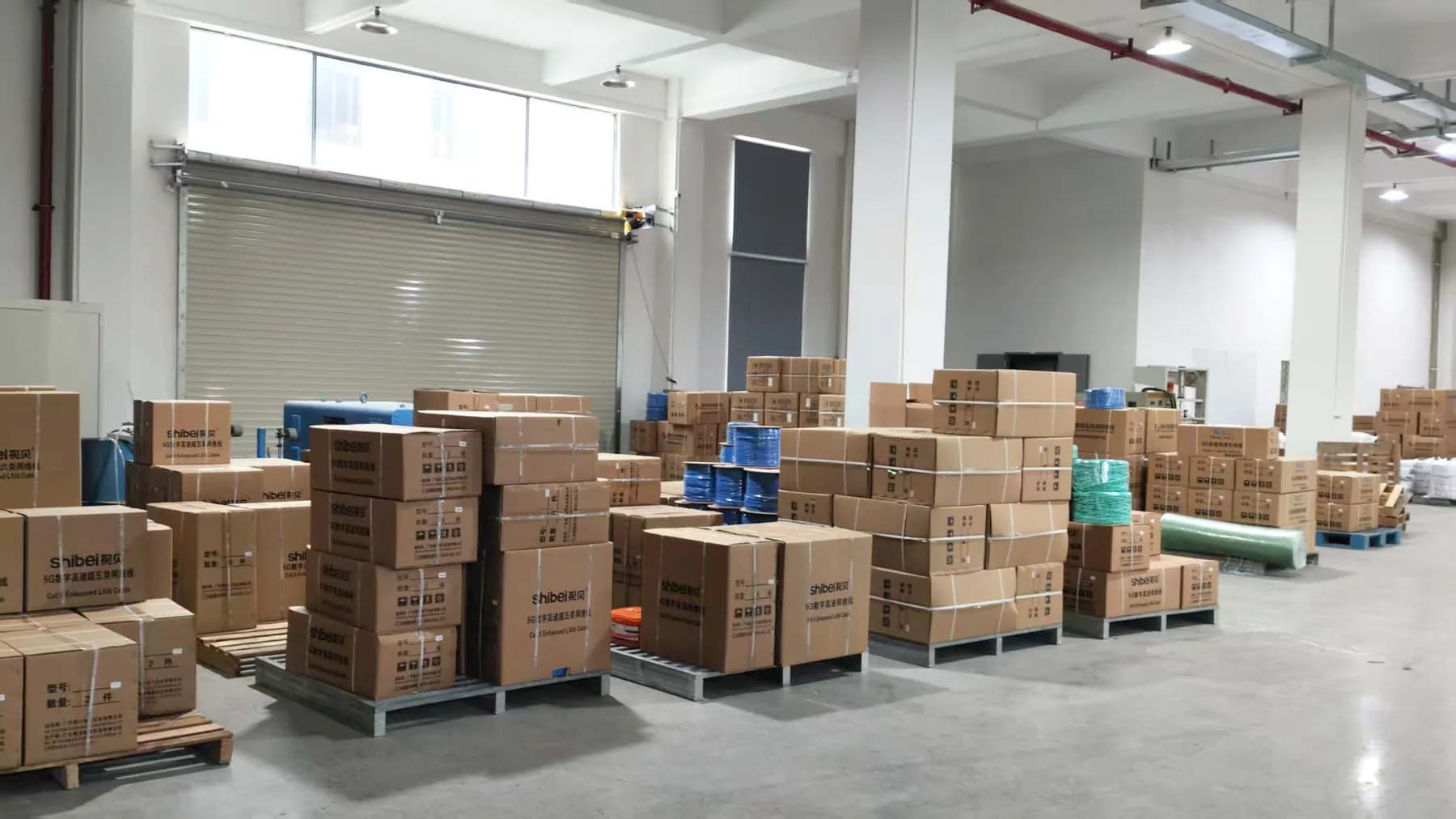 Warehouse aisle with cartons and reels of finished cable